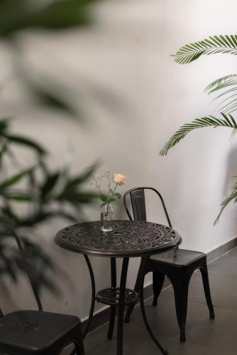 a table and chair with a vase of flowers on it at Le Soleil Boutique Hotel in Da Lat