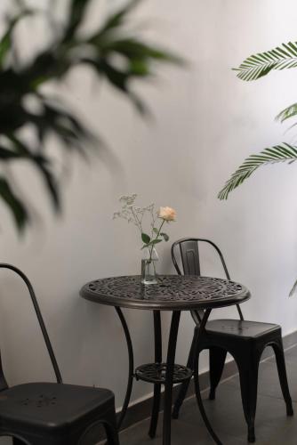 a table and chairs with a vase of flowers on it at Le Soleil Boutique Hotel in Da Lat