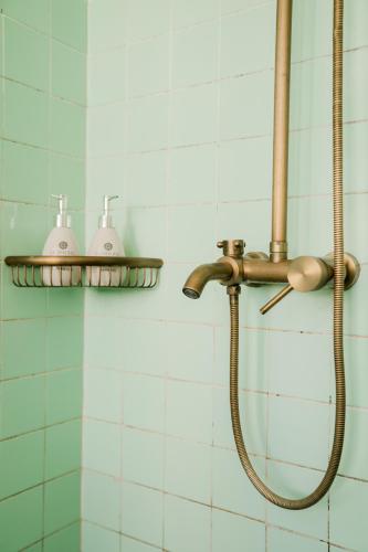 a bathroom with a shower with two lights on the wall at Le Soleil Boutique Hotel in Da Lat