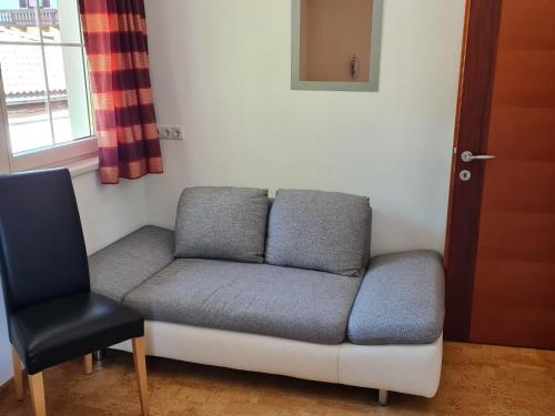 a couch and a chair in a room at Holiday flat Aschau in Aschau