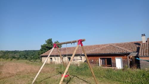 a swing set in front of a house at la ferme de fenivou in Boulieu-lès-Annonay