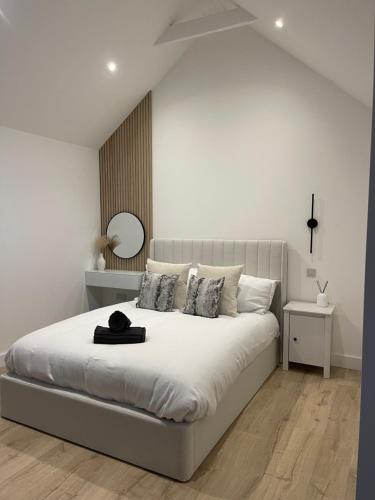 um quarto branco com uma grande cama branca com almofadas em The Lodge Hideaway in Cowes em Gurnard