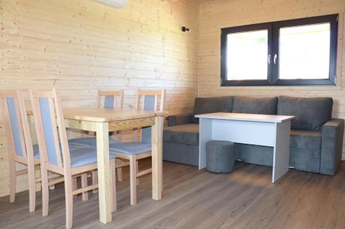 a living room with a table and chairs and a couch at Nowy Domek Pod Czereśniami in Wisełka
