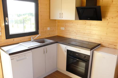 a small kitchen with a sink and a microwave at Nowy Domek Pod Czereśniami in Wisełka