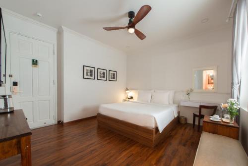 a bedroom with a bed and a ceiling fan at Le Soleil Boutique Hotel in Da Lat