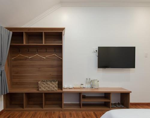 a room with a tv on a wall at Le Soleil Boutique Hotel in Da Lat