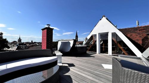 una terraza con una casa blanca con techo en Historical Luxury Homes - Exclusive Selection, en Freiburg im Breisgau