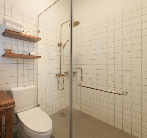a bathroom with a toilet and a glass shower at Le Soleil Boutique Hotel in Da Lat