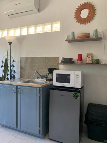 a kitchen with a microwave on top of a refrigerator at Casa Madero #1, Central Studio Apartment 1 Block From Malecon in La Paz