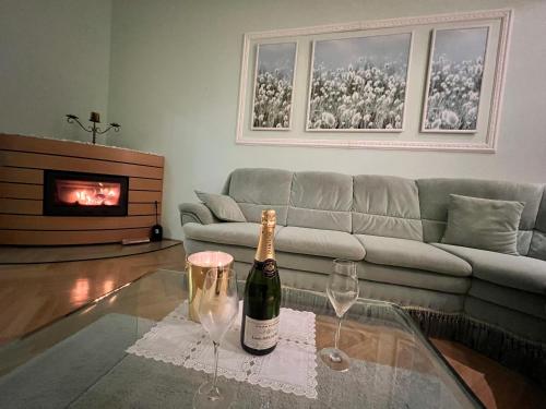 a living room with a bottle of champagne and two wine glasses at Sadova luxury apartment in Karlovy Vary