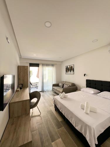 um quarto de hotel com uma cama e um sofá em Square Residence em Ulcinj