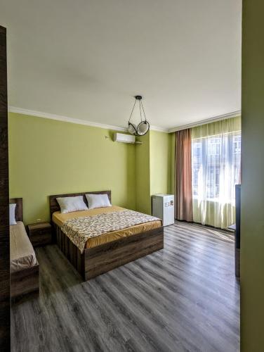 a bedroom with a bed in a room with green walls at Corner house in K'obulet'i