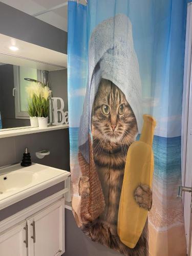 un chat dans un rideau de douche tenant une banane dans l'établissement Appt Climatisé de charme-moderne - Vue Mer Club Vacances Restanques Golfe Saint-Tropez - Les Roses - Grimaud, à Grimaud