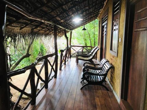 a porch of a house with two benches on it at Ganesh Garden Beach Cabanas in Tangalle