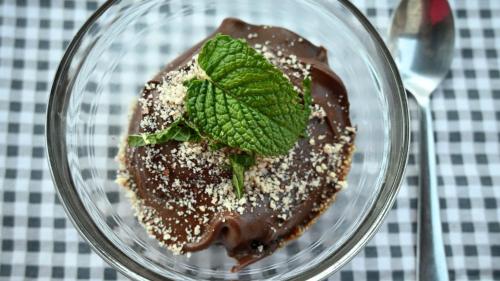 a glass bowl with chocolate and a green leaf on it at Quinta Ecológica da Peneda Agroturismo by Peneda ecofarm in Arcos de Valdevez
