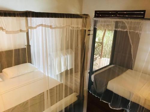 a small room with a window with curtains at Ganesh Garden Beach Cabanas in Tangalle