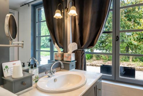 a bathroom with a sink and a large window at Domaine de Geffosse in Pont-lʼÉvêque