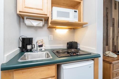 een kleine keuken met een spoelbak en een fornuis bij Mountainside Inn 316 by Alpine Lodging Telluride in Telluride