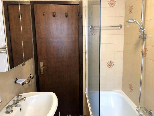 een badkamer met een douche, een wastafel en een bad bij 051 Trilocale piano terra, Pinzolo in Pinzolo