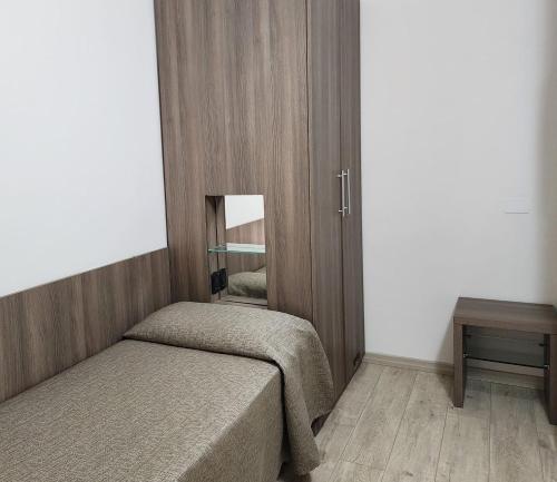 a small bedroom with two beds and a mirror at Hotel Miramare Dipendenza in Pineto