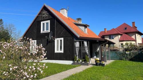 a black house with an orange roof at Domek Mazury Pisz in Pisz