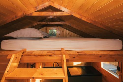 馬卡爾斯卡的住宿－Tiny house Aria，树屋中一间房间中间的一张床位