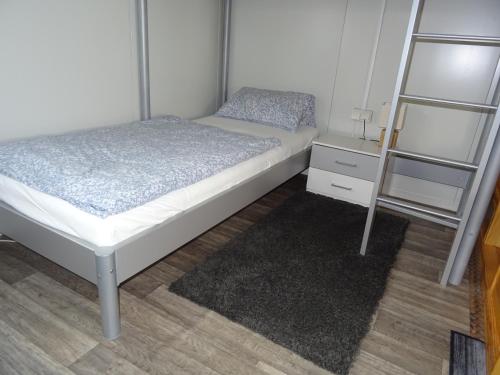 a small bedroom with a bed and a night stand at La Casita del Pueblo in Bechtsrieth