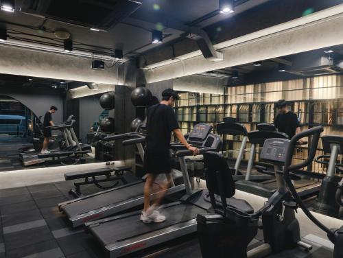 a man walking on a treadmill in a gym at Art Mai Gallery Nimman Hotel Chiang Mai in Chiang Mai
