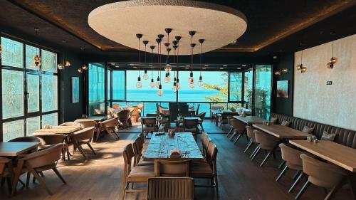 a restaurant with tables and chairs and a large window at BİLİRİS HOTEL in Trabzon