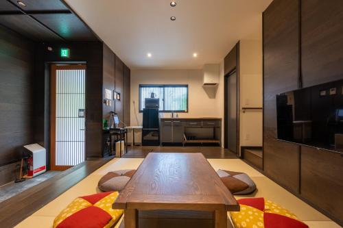 a living room with a wooden table and a kitchen at Irodori Hotel SAI in Fukuoka