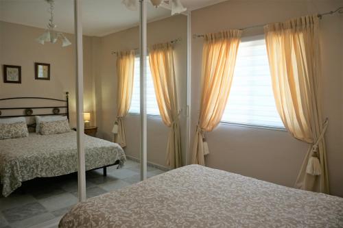 um quarto com 2 camas e um espelho em Golf del Sur Apartment - magnificent panorama of the ocean, el Teide, and Montaña Roja em San Miguel de Abona