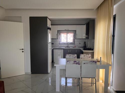 een keuken met een tafel en stoelen in een kamer bij MAYA APARTMANI in Kuşadası