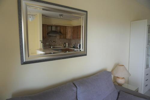 um espelho pendurado numa parede ao lado de um sofá em Golf del Sur Apartment - magnificent panorama of the ocean, el Teide, and Montaña Roja em San Miguel de Abona