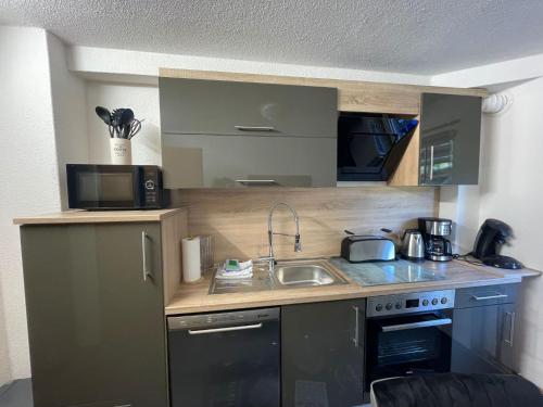 eine kleine Küche mit einer Spüle und einer Mikrowelle in der Unterkunft Ferienwohnung Elvira in Bad Wildungen