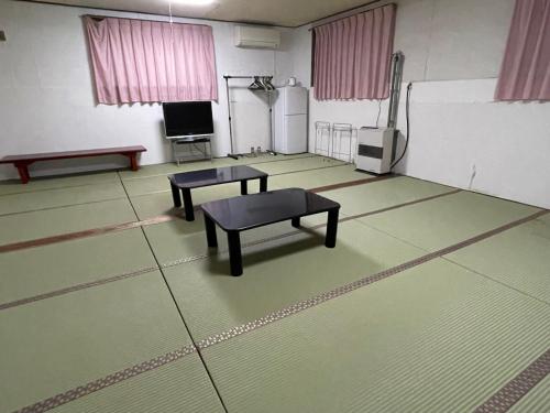 an empty room with two tables and a bench in it at Hotel Sejour Mint in Hakuba in Hakuba