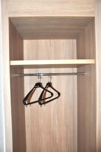 a closet with two hangers in a wooden door at NEO HOTEL in Caravaca de la Cruz