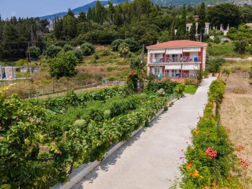 a garden with a house in the background at Diona Studios in Lourdhata