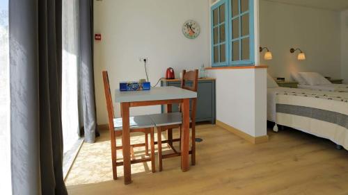 a room with a table and chairs and a bed at Quinta Ecológica da Peneda Agroturismo by Peneda ecofarm in Arcos de Valdevez
