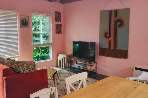 a living room with a couch and a tv at Bastion Abode ~ 900 meters from the beach! in Mallacoota