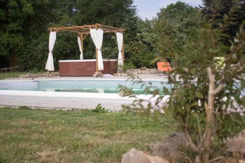 - une piscine avec un kiosque, une table et une chaise dans l'établissement Chez mumu, à Frévillers
