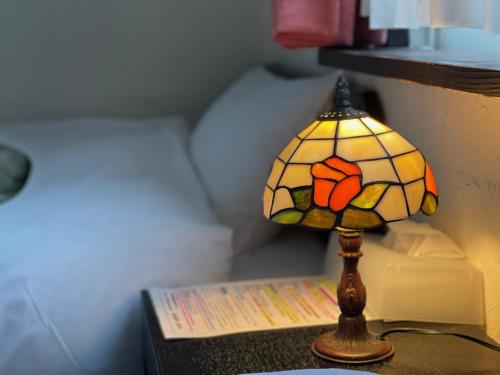 a lamp sitting on a table with a book at Hotel Sejour Mint in Hakuba in Hakuba