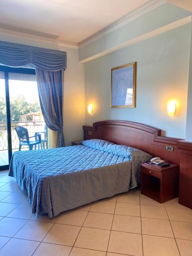a hotel room with a bed and a balcony at Hotel Sangro in Mozzagrogna