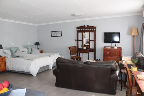 Sala de estar con cama y TV en Giraffe's Rest, Self Catering Studio Apartment en White River