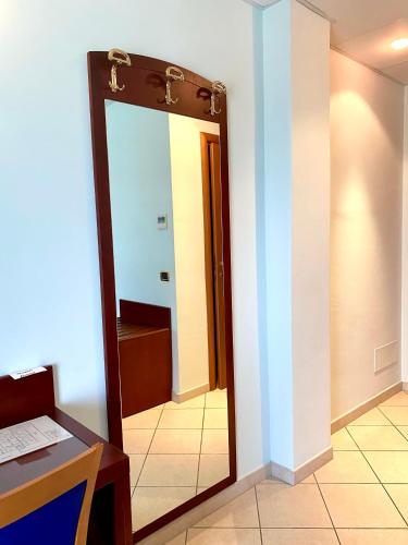 a mirror in front of a room with a bathroom at Hotel Sangro in Mozzagrogna