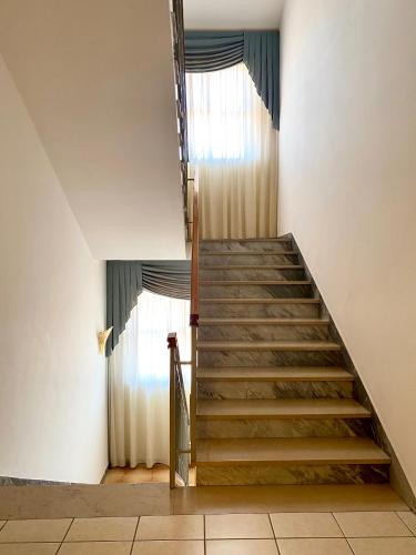 a staircase in a building with two windows at Hotel Sangro in Mozzagrogna