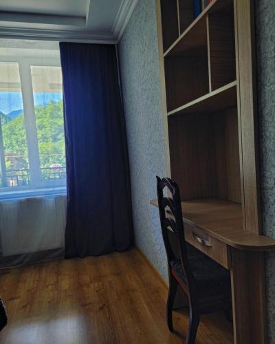 a desk with a chair in a room with a window at Family hotel mountain panorama in Borjomi