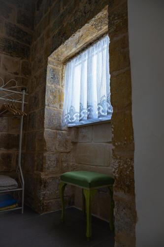 a green stool in a room with a window at Lemon Tree Relais by CX Collection in Żabbar