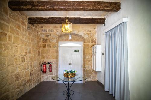 a room with a table in a stone wall at Lemon Tree Relais by CX Collection in Żabbar
