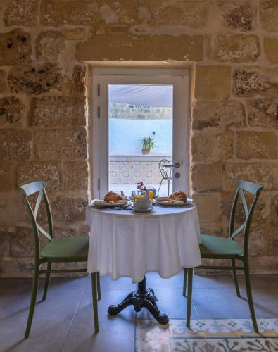 a table with food on it in a room with a window at Lemon Tree Relais by CX Collection in Żabbar