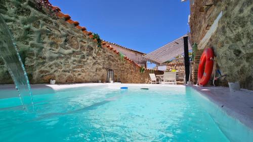 una piscina con una fuente de agua en El Edén Casas Rurales con Piscina y Jacuzzi, en Montánchez